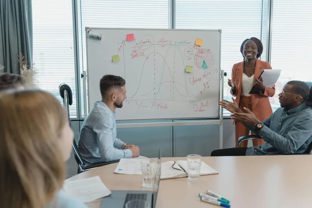 A diverse team brainstorming components of the AI ecosystem on a whiteboard (illustrative). In 2026, collaboration and a holistic view are key to succeeding in AI.