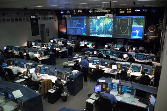 NASA’s Mission Control Center in Houston teams of engineers (including flight dynamics specialists) work together to monitor and guide space missions. Astrodynamics specialists often serve as “flight dynamics” experts, planning orbits and maneuvers to keep spacecraft on track.
