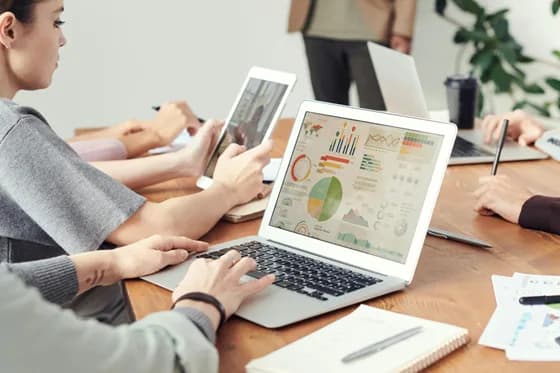 A team of business analysts reviewing data visualizations in a modern workplace. Collaborative analysis and open discussion help ensure that insights are accurate and actionable. In 2026, business analysts often work cross-functionally to translate data findings into strategic decisions.