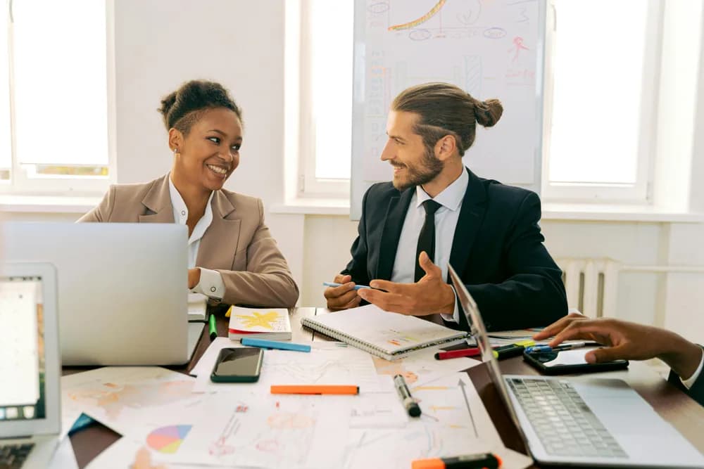 Business analysts collaborating in a modern office. In 2026, the role of a Business Analyst involves not just number-crunching, but also teamwork and strategic thinking.