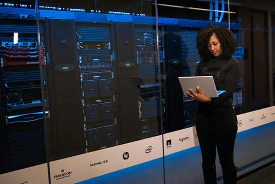 A cloud development engineer works on server infrastructure in a data center, reflecting the hands-on nature of managing cloud platforms