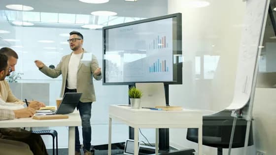 Team of professionals discussing data on a large screen. In data analytics engineering, collaboration and clear communication of insights are crucial