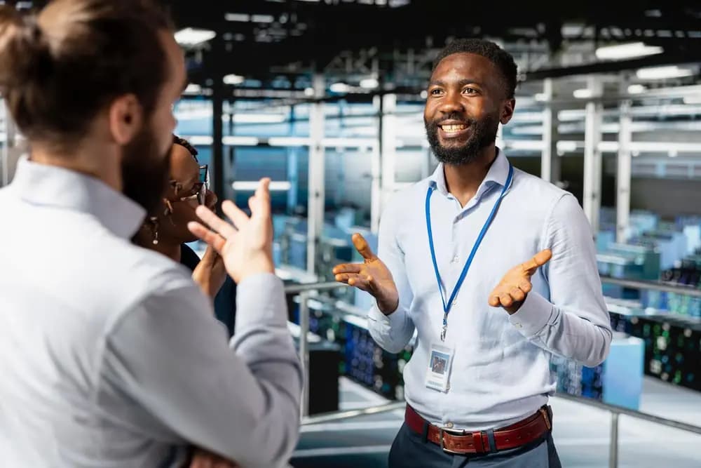 DevOps engineers collaborating in a modern data center discussing cloud infrastructure, CI/CD pipelines, and system automation in 2026