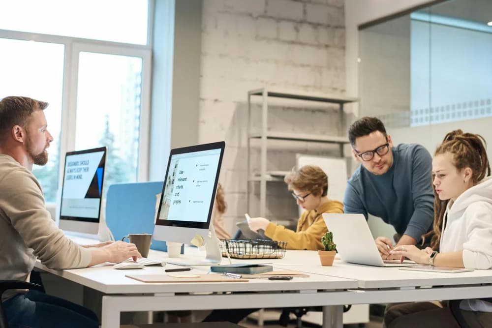 DevOps engineers collaborating in a modern office, working on CI/CD pipelines, cloud infrastructure, and automation tools as part of DevOps engineering workflows in 2026.