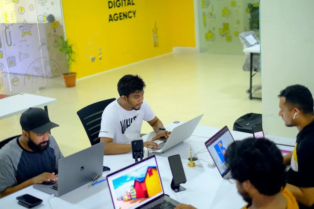 Digital marketing team collaborating on laptops in a modern workspace, illustrating AI-driven digital-marketing-program in 2026 and scalable SEO and automation strategies