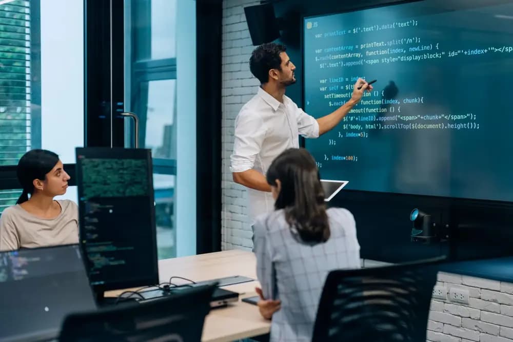 Full stack developer teaching JavaScript and web application development to students during a fullstack-development-program in 2026, demonstrating real-world coding skills