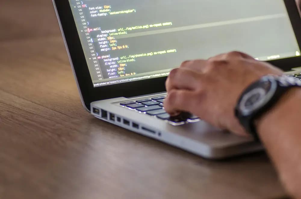 Cybersecurity engineer writing and reviewing secure code on a laptop, focusing on application security, vulnerability prevention, and digital protection.