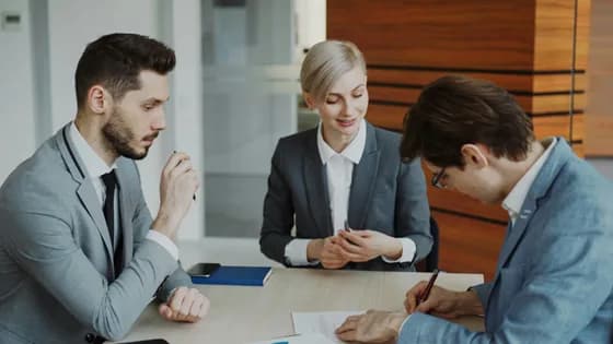 Three legal professionals collaborate on a document, illustrating how human expertise and AI-generated insights work hand-in-hand in modern law
