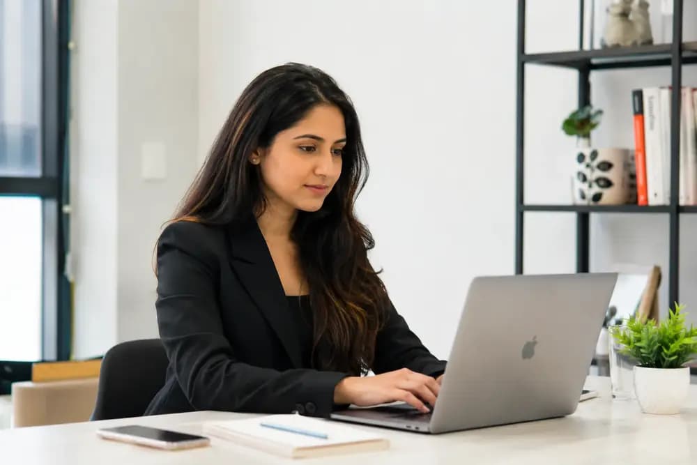 Professional woman working on a laptop while managing online reputation and digital brand presence.