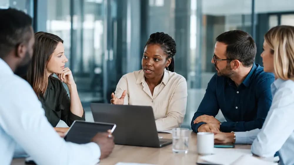 Product owner leading a diverse product team in a modern office while discussing backlog priorities, roadmap strategy, and Agile product planning for 2026.