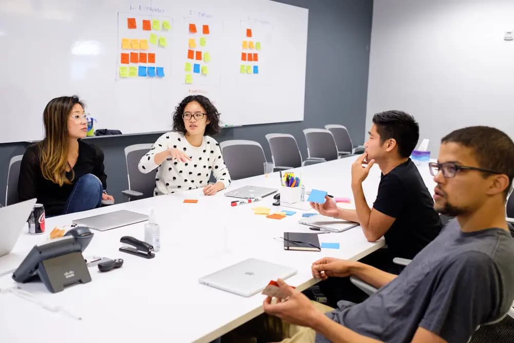 Product Owner management in 2026 strategy meeting – agile product owner leading diverse development team using AI analytics dashboard in modern office Refonte Learning Product Owner program