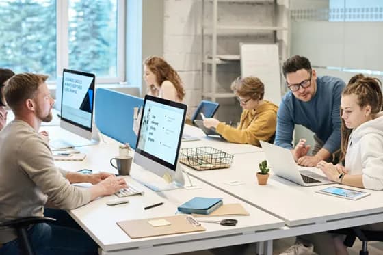 AI professionals collaborating in a modern office to implement machine learning algorithms. In 2026, Q-learning a key reinforcement learning technique continues to thrive through teamwork and innovation.