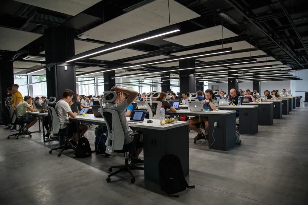 Quality assurance teams in 2026 work closely with developers and IT, often in agile environments. QA Automation Engineers collaborate with cross-functional teams to integrate testing into every step of delivery, as shown in this modern office scene. Automation and teamwork go hand-in-hand to ensure software reliability.