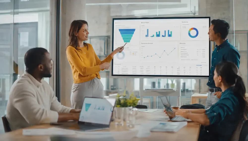 Revenue operations team reviewing sales pipeline dashboards during a modern office strategy meeting