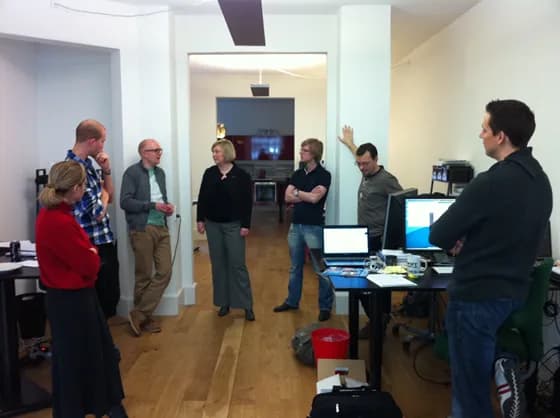 A Scrum Master facilitating a daily stand-up meeting. In 2026, effective Scrum Masters excel at guiding these quick sync-ups to keep teams aligned and aware of blockers