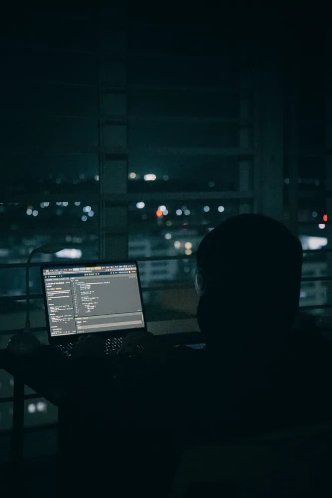 Cybersecurity expert monitoring systems for threats during a night shift.
